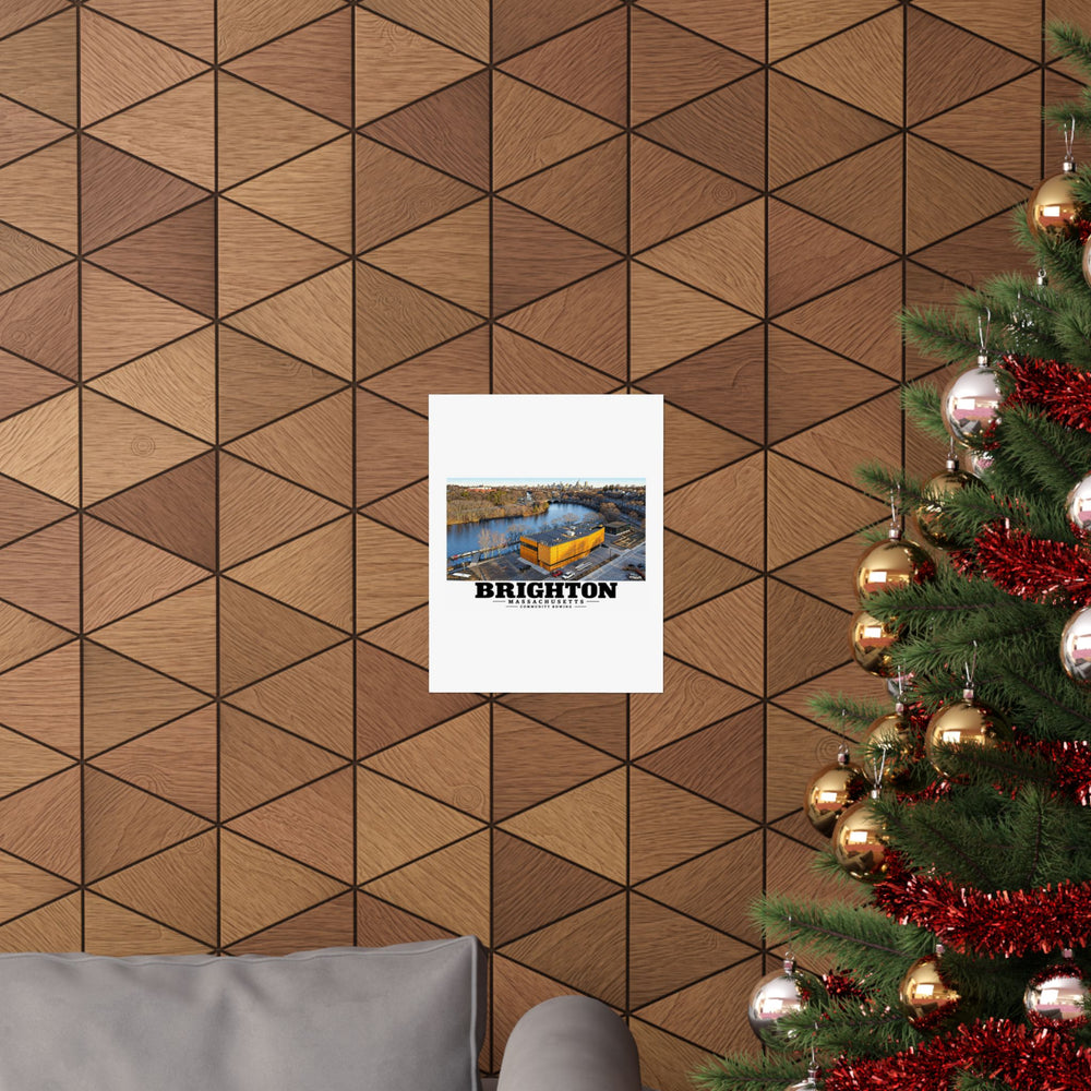 Community Rowing aerial building and river poster on a wood wall beside a decorated evergreen
