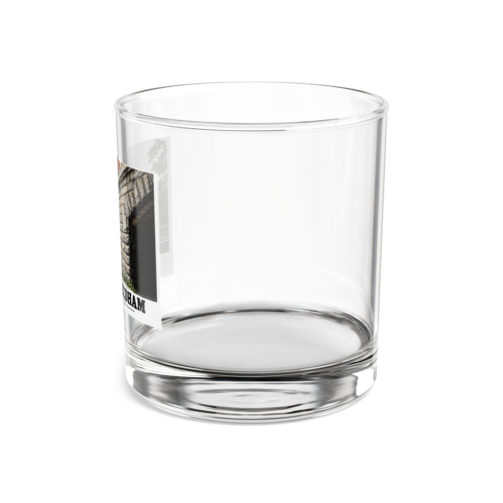 Side view of a clear rocks glass with part of the Echo Bridge artwork showing a row of stone arches and a brick upper band, with Newton/Needham lettering visible on the left.