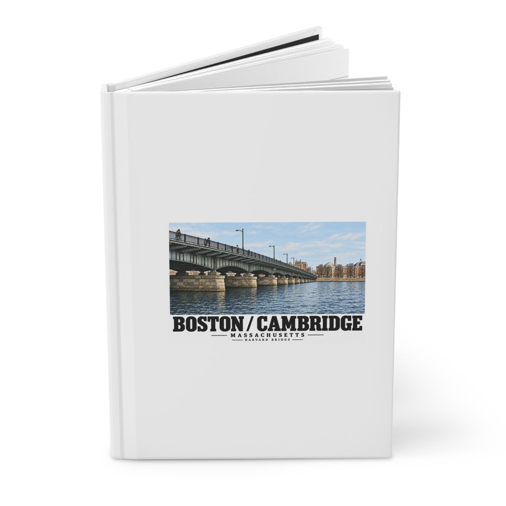 Partly opened journal showing its cover with Harvard Bridge artwork and Boston/Cambridge lettering