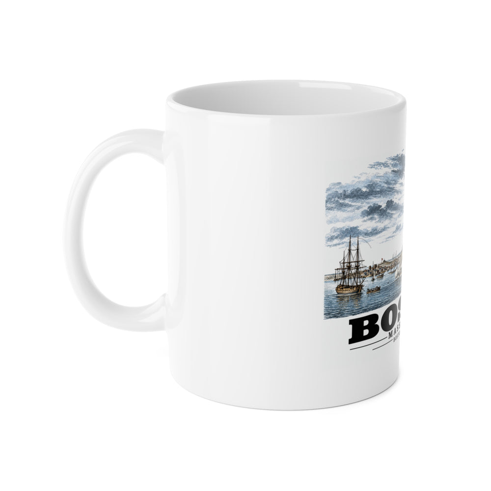 White mug with handle at left and part of the Boston Harbor waterfront scene with sailing ships print at right