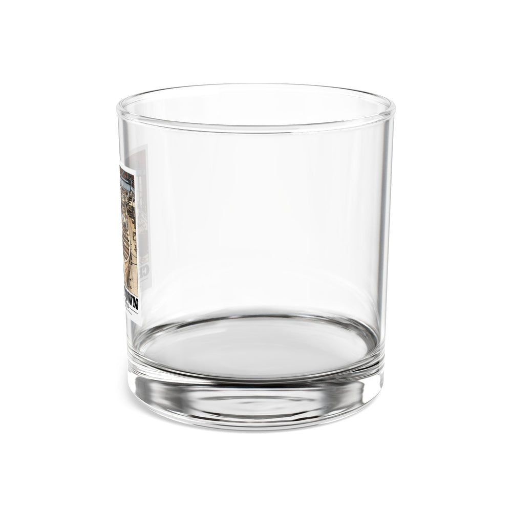 Left side of clear rocks glass showing partial small-boat building artwork
