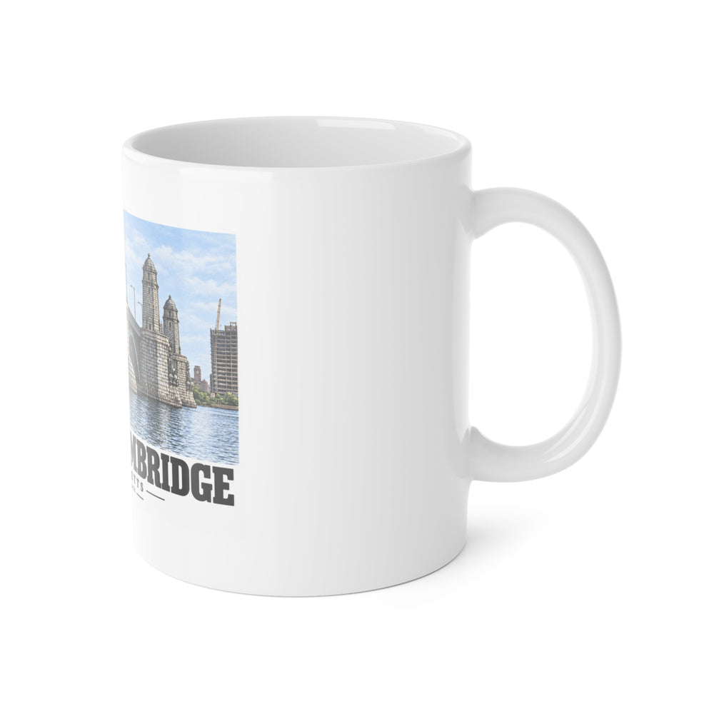White ceramic mug with its handle on the right and part of the Longfellow Bridge design visible on the left.