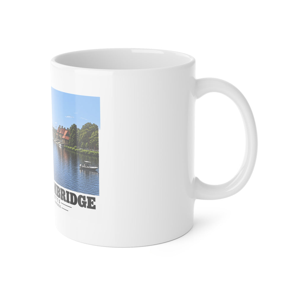 White mug with handle at right and part of the Anderson Memorial Bridge distant river view print at left