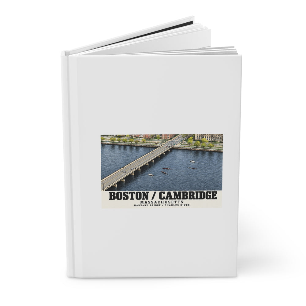 Partly opened white hardcover journal showing Harvard Bridge aerial view with scullers on the Charles River artwork on the front