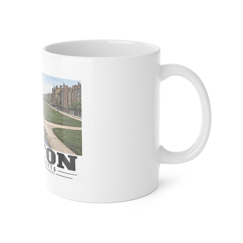 White mug with handle at right and part of the Charles River Embankment riverside path, lawn and buildings print at left