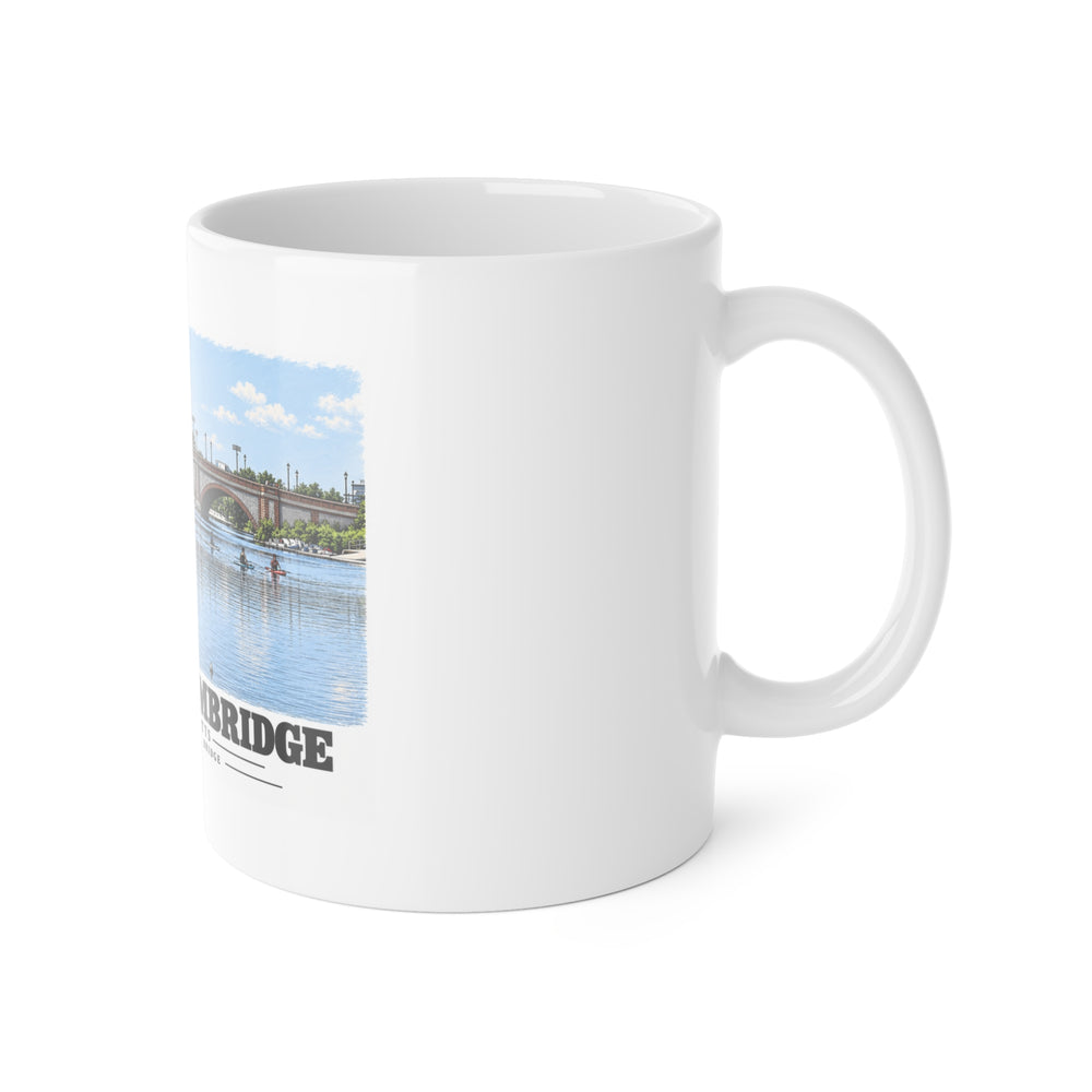 White mug with handle at right and part of the Anderson Memorial Bridge and scullers print at left