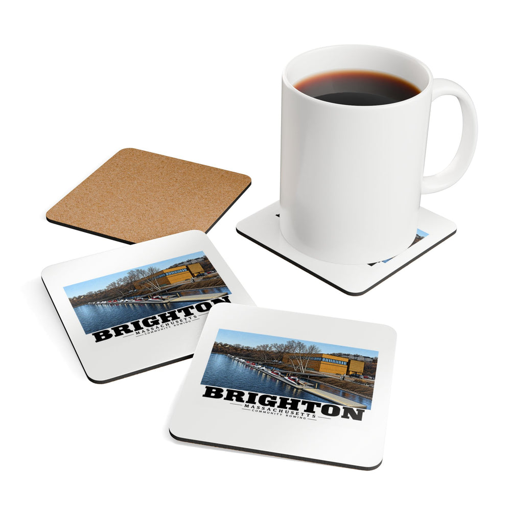 Coasters showing Community Rowing building, dock and boats artwork beside a plain white mug of coffee and a coaster's cork reverse