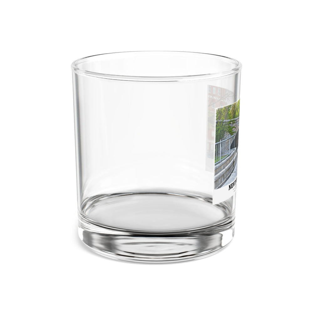 Side view of clear rocks glass with mostly unprinted surface and part of Finlay Dam stone arches and water print at right