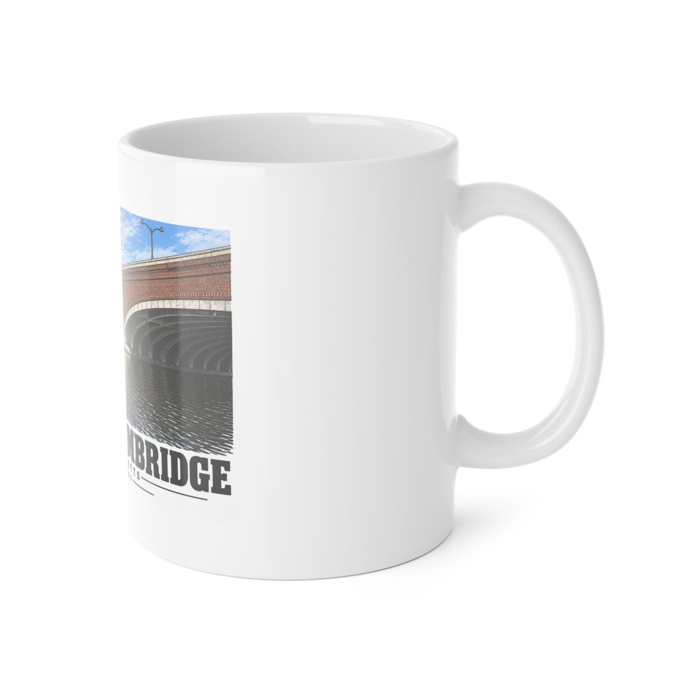 White mug with handle at right and part of the Eliot Bridge close red brick arch view print at left