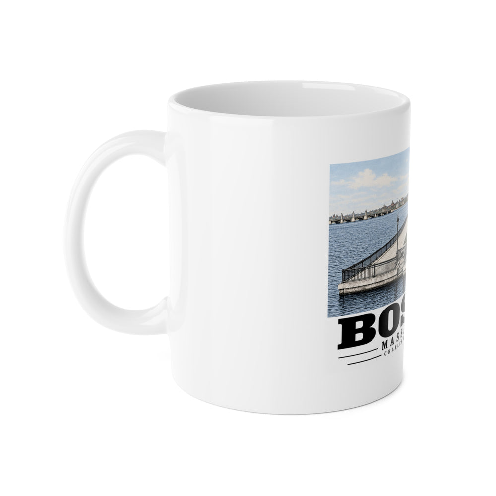 White mug with handle at left and part of the Charles River Embankment riverside path, lawn and buildings print at right