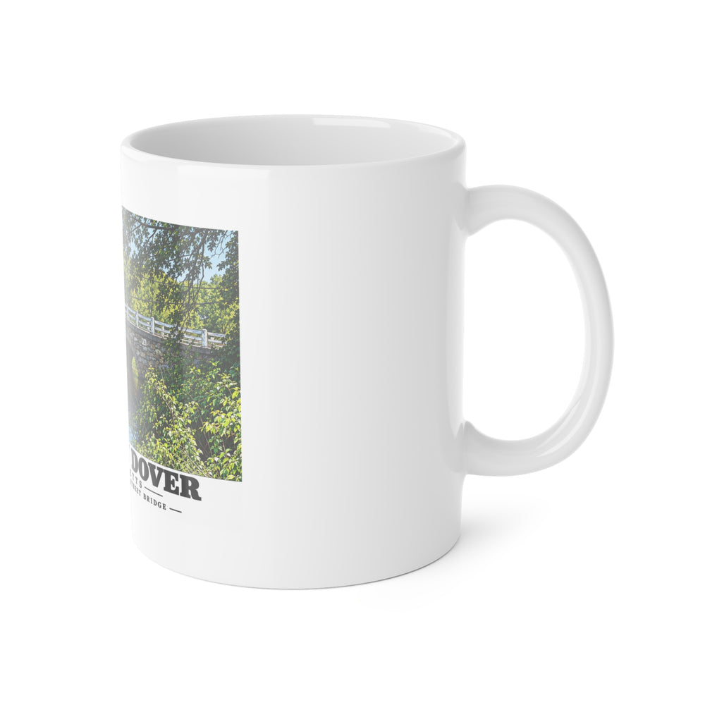 White mug with handle at right and part of the Central Avenue / Centre Street Bridge stone arches and river print at left
