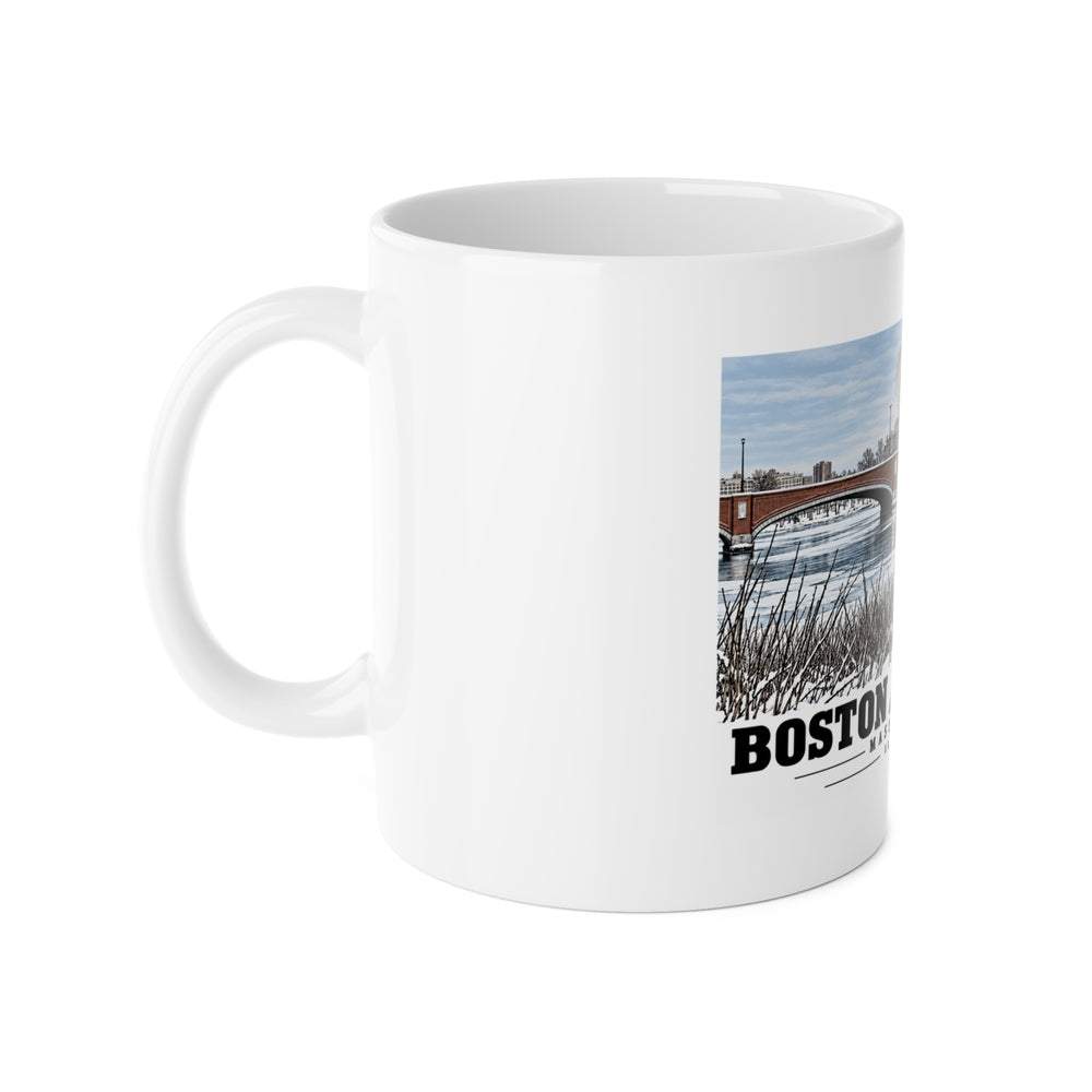 White mug with handle at left and part of the Eliot Bridge winter river view with snow and bare trees print at right