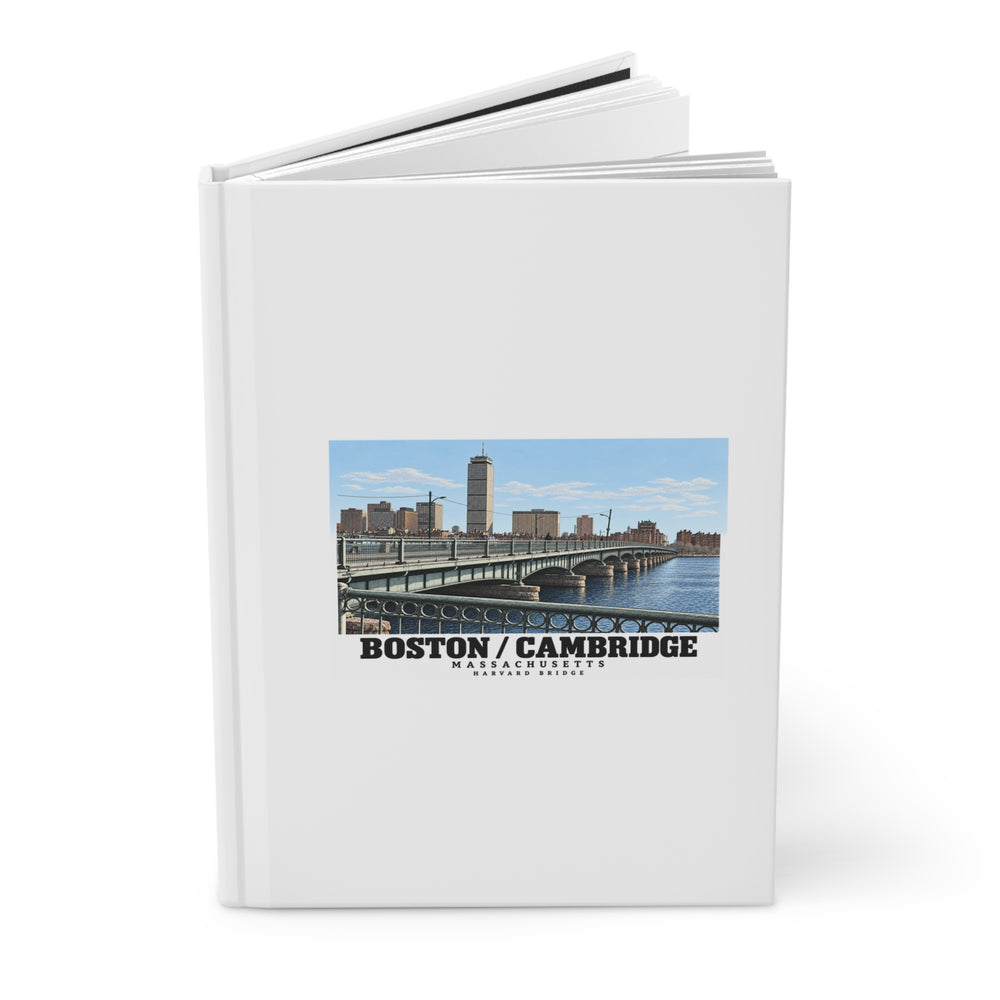 Partly opened journal showing its cover with Harvard Bridge artwork and Boston/Cambridge lettering