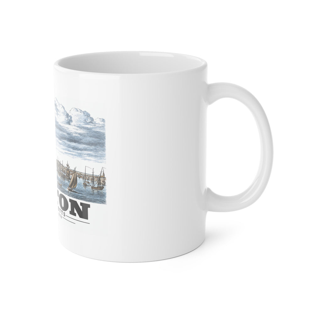 White mug with handle at right and part of the Boston Harbor waterfront scene with sailing ships print at left
