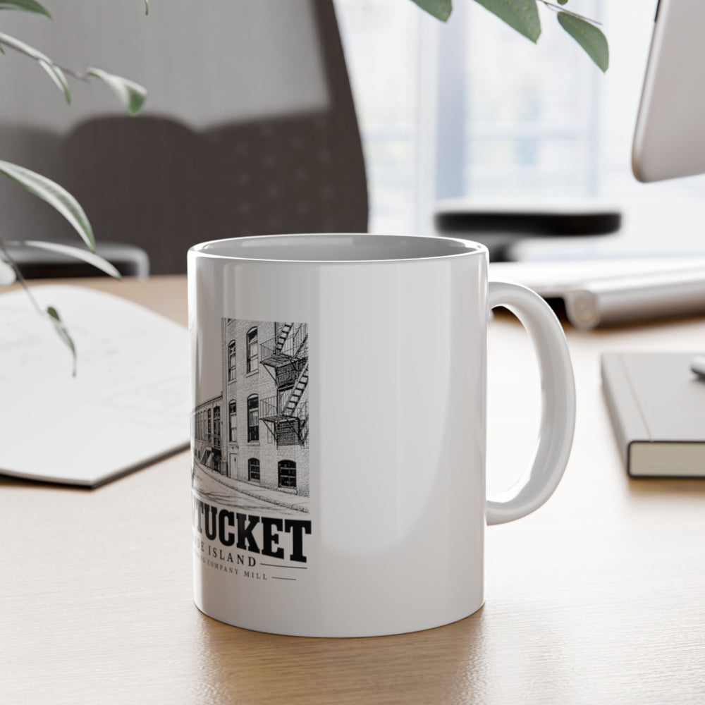 Pawtucket Hope Webbing Company Mill — White 11-ounce ceramic mug, on desk with handle visible.