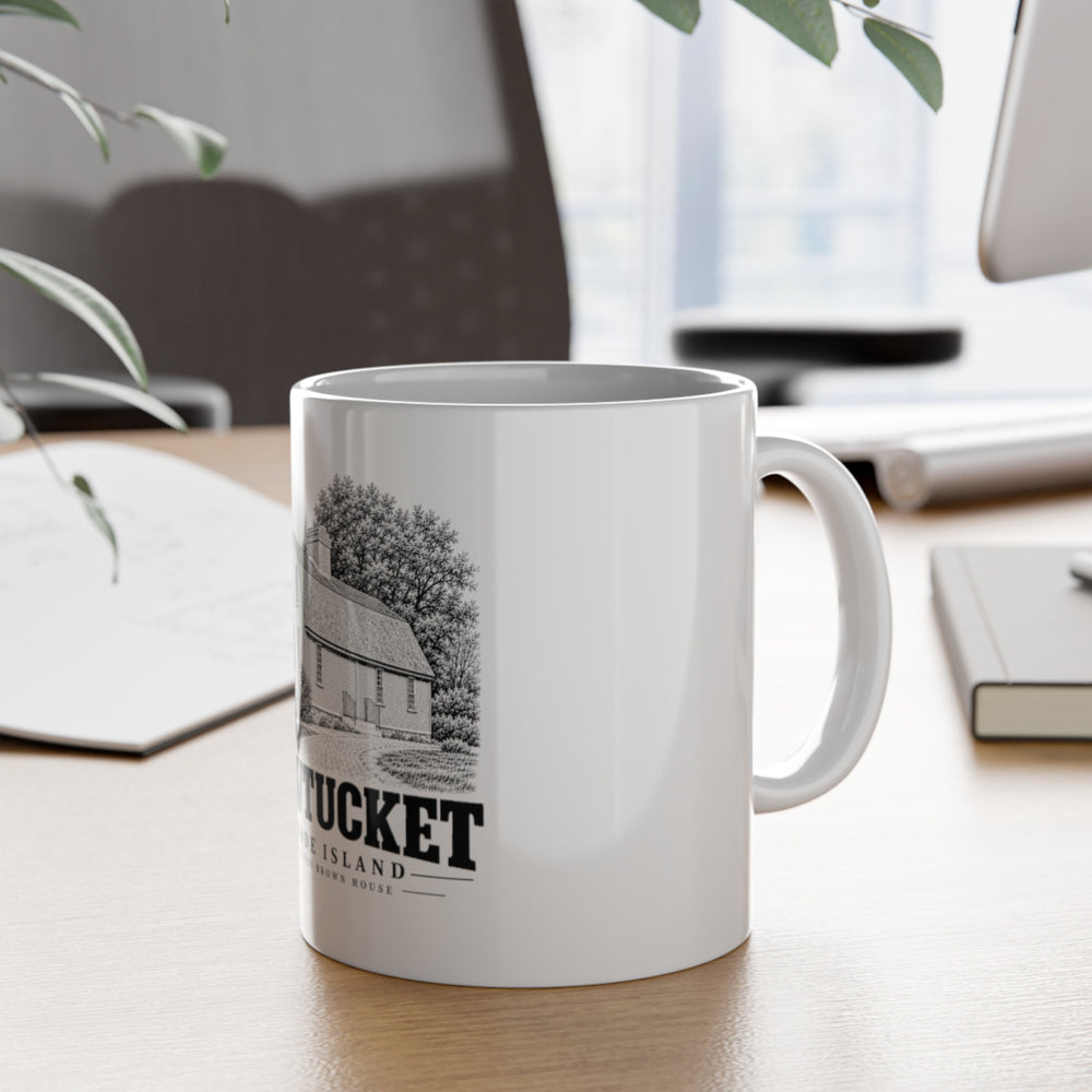 Pawtucket Sylvanus Brown House — White 11-ounce ceramic mug, on desk with handle visible.