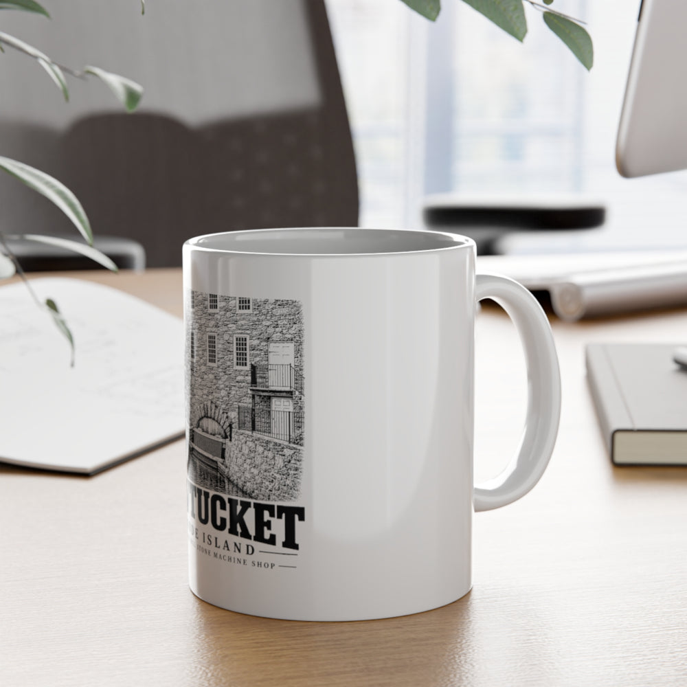 Pawtucket Wilkinson Mill Stone Machine Shop — White 11-ounce ceramic mug, on desk with handle visible.