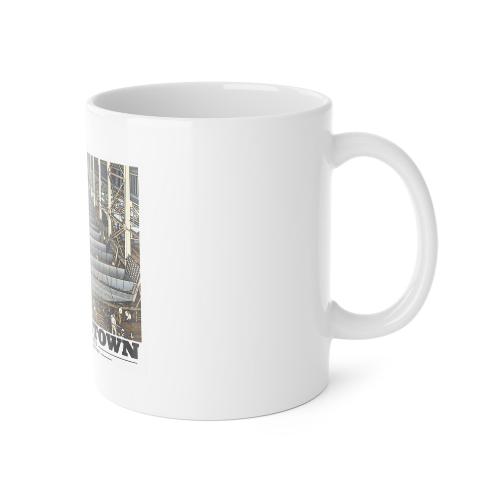 Right side of ceramic mug showing handle and edge of landing-craft production line artwork