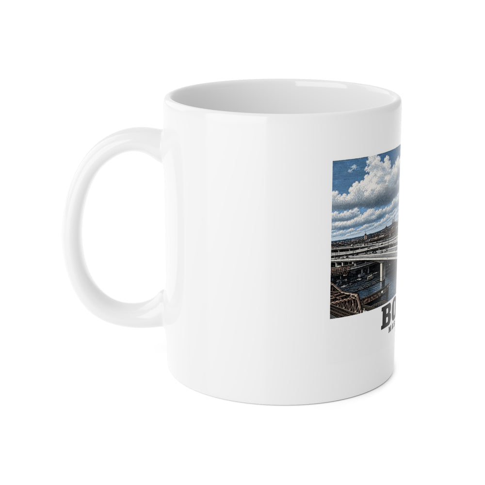 White mug with handle at left and part of the Zakim Bunker Hill Bridge cable-stayed towers and Charles River print at right