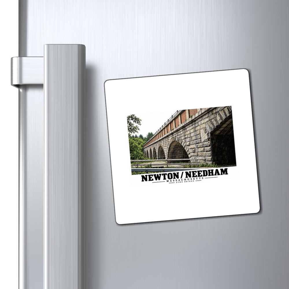 Square magnet with Echo Bridge artwork showing a row of stone arches and a brick upper band, with Newton/Needham lettering displayed on a refrigerator door beside its handle.