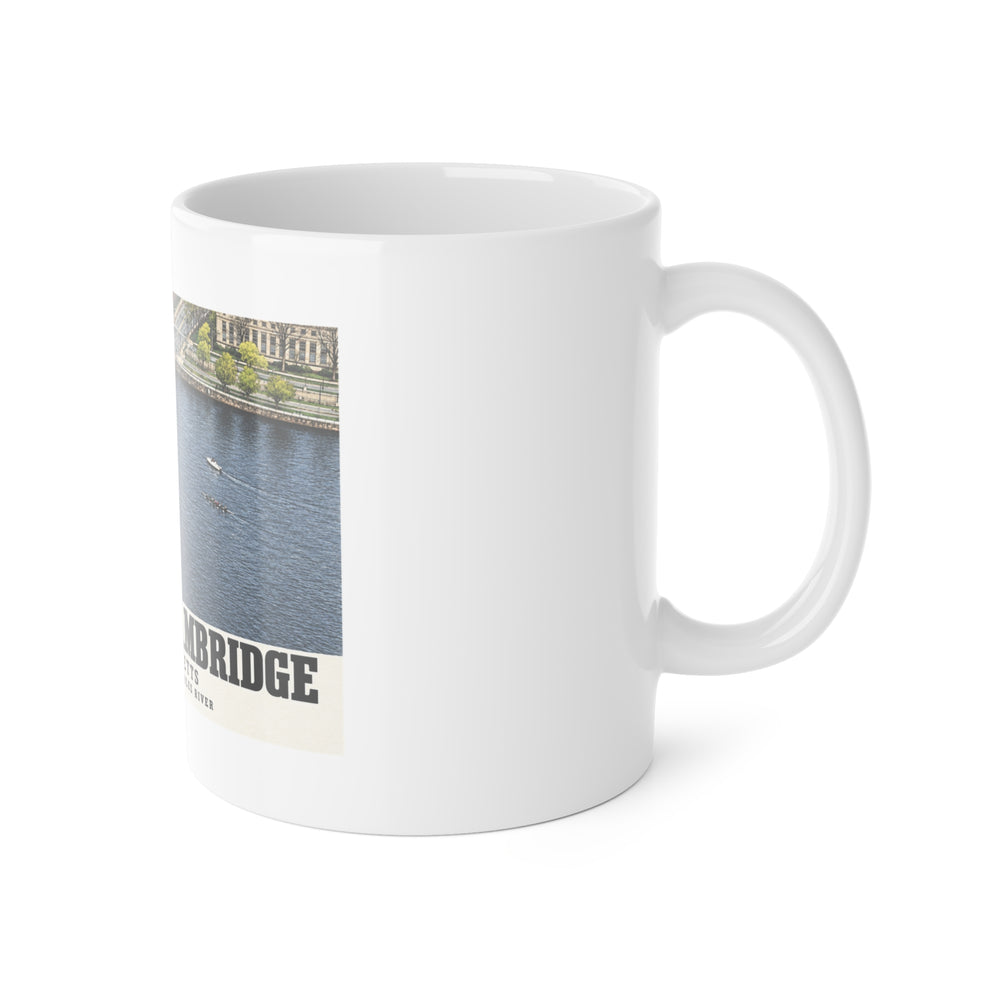 White mug with handle at right and part of the Harvard Bridge aerial view with scullers on the Charles River print at left