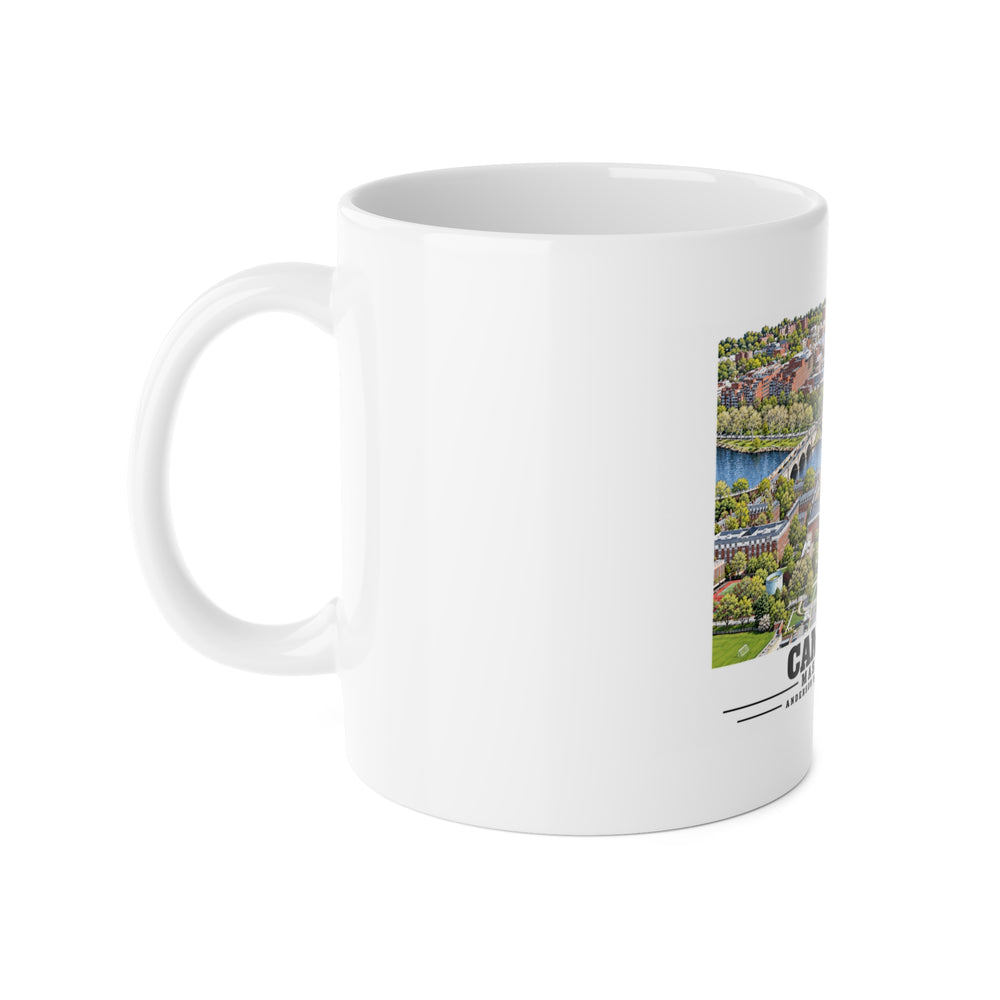 White ceramic mug with its handle on the left and part of the Cambridge design visible on the right.