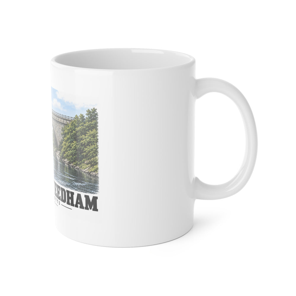 White ceramic mug with its handle on the right and part of the Echo Bridge artwork showing a stone arch over a river and trees, with Newton/Needham lettering visible on the left.