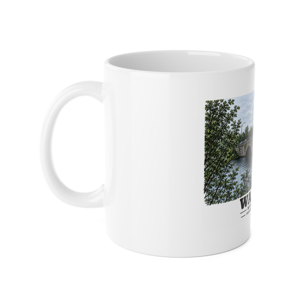 White mug with handle at left and part of the Prospect Street Bridge stone arches and river print at right