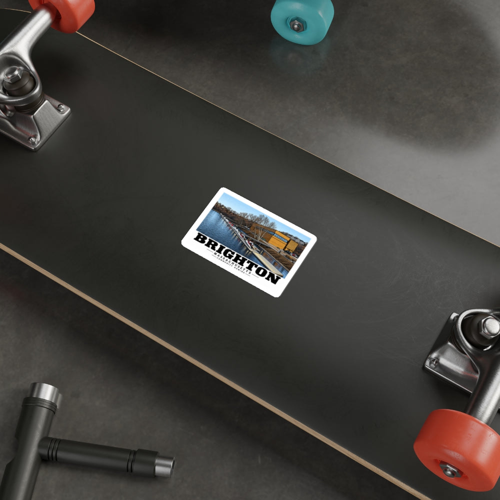 Sticker showing Community Rowing building, dock and boats artwork on the underside of a skateboard