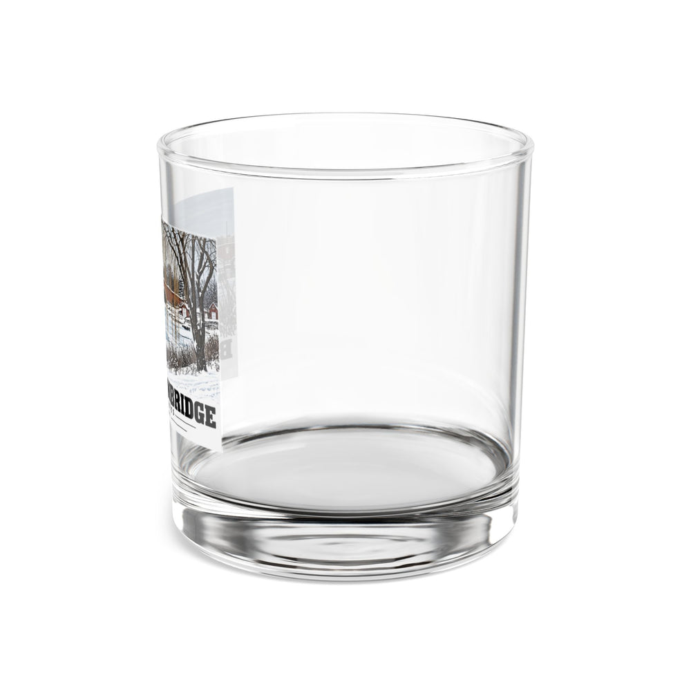 Side view of clear rocks glass with mostly unprinted surface and part of Eliot Bridge winter river view with snow and bare trees print at left