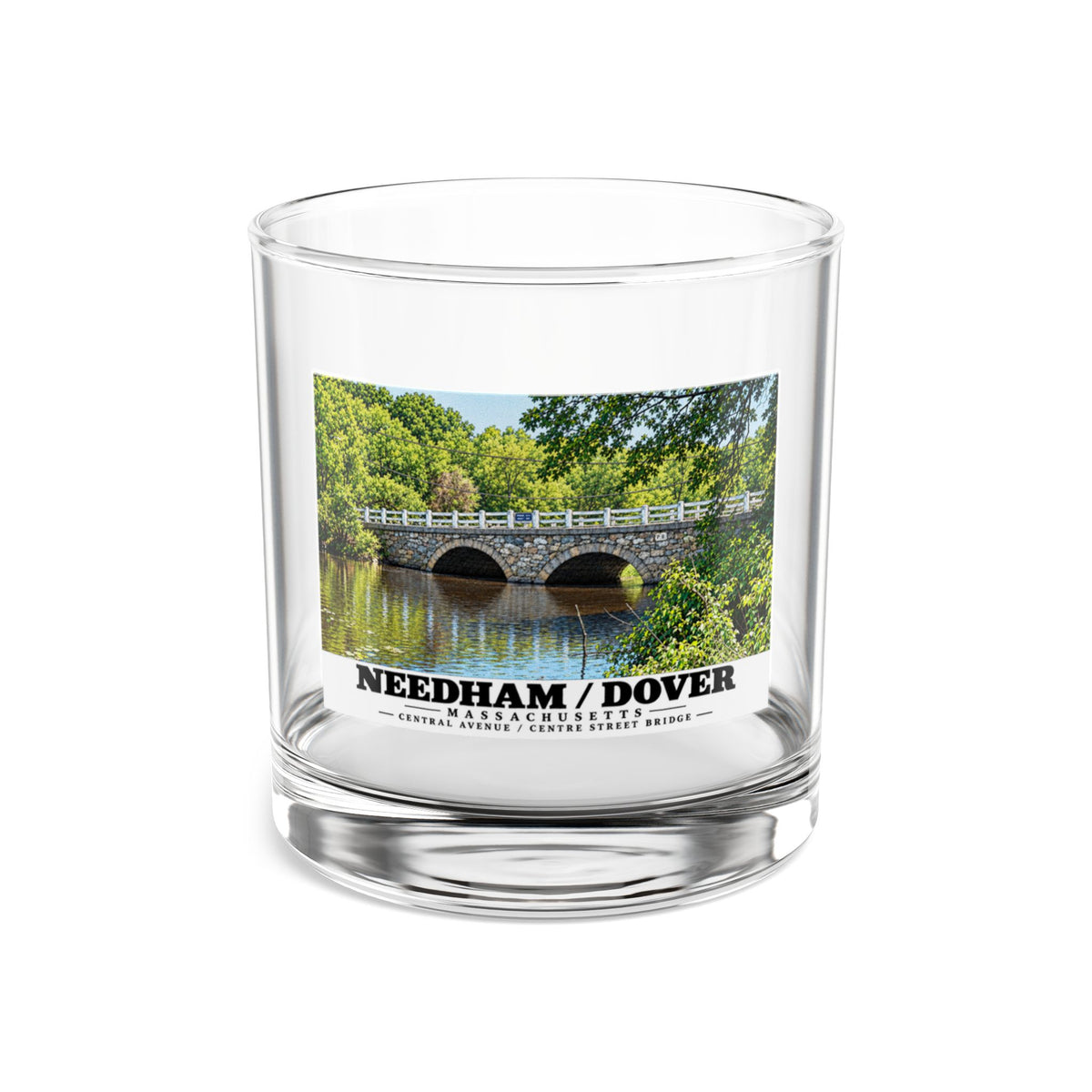 Clear rocks glass showing Central Avenue / Centre Street Bridge stone arches and river artwork and Needham/Dover lettering