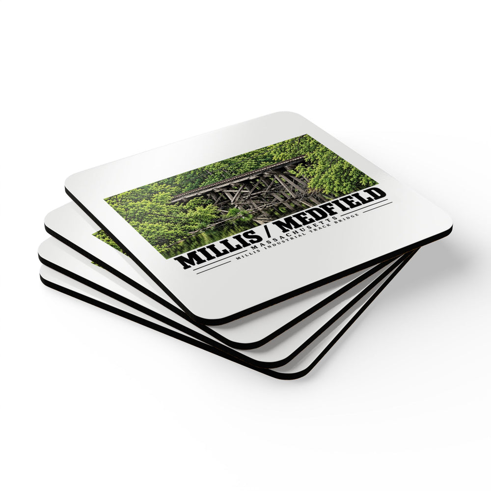 Stack of square coasters with Millis Industrial Track wooden railway trestle and green foliage artwork visible on the top coaster