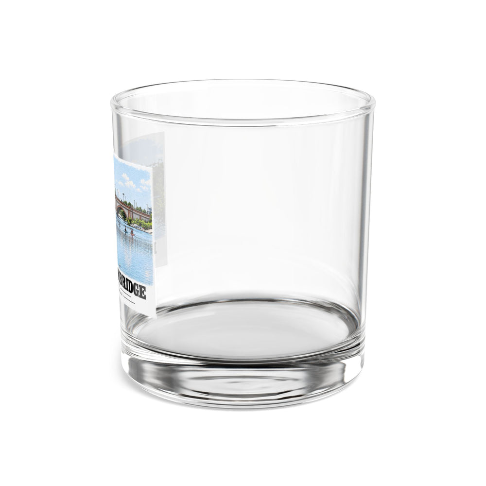 Side view of clear rocks glass with mostly unprinted surface and part of Anderson Memorial Bridge and scullers print at left
