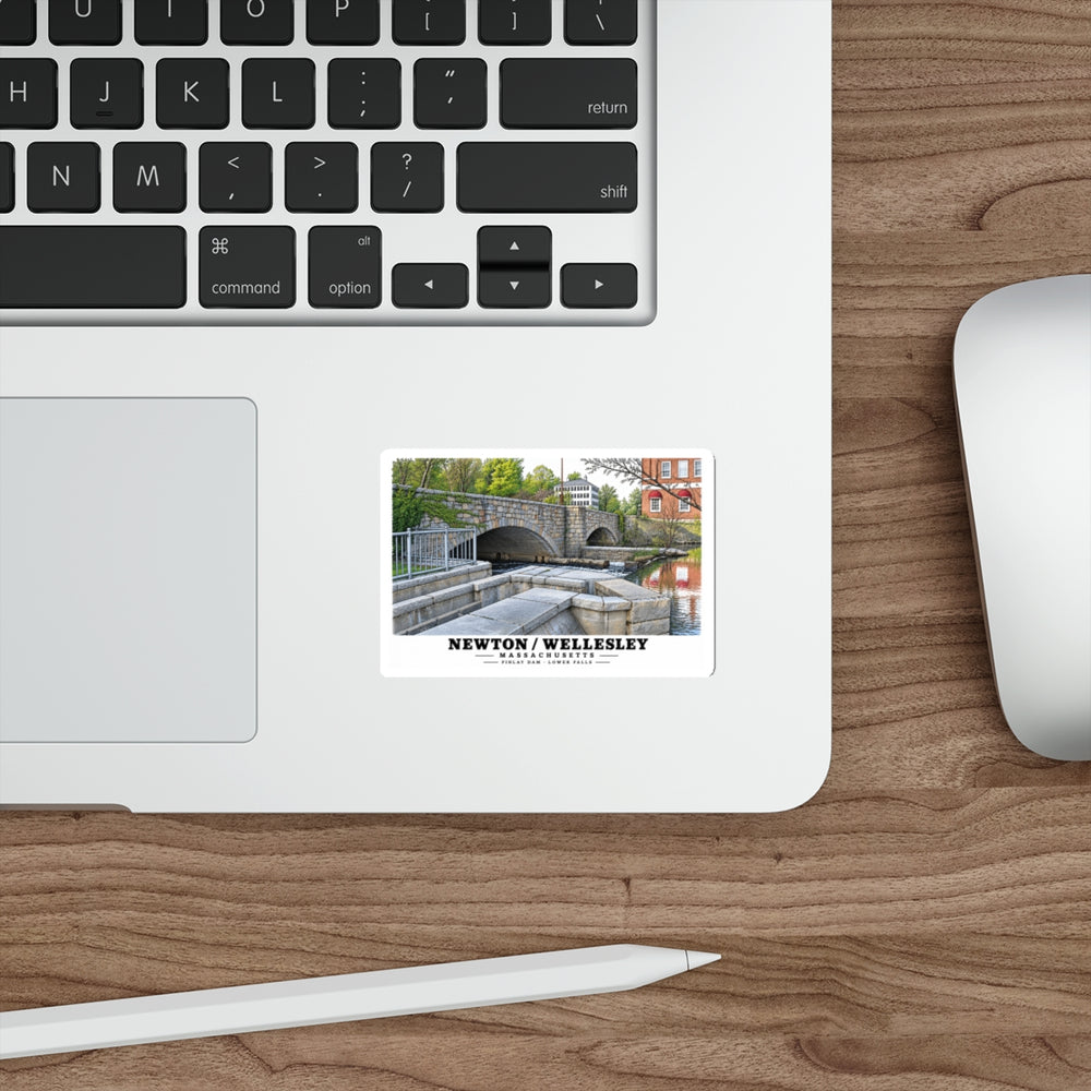 Sticker showing Finlay Dam stone arches and water artwork on a laptop beside its keyboard