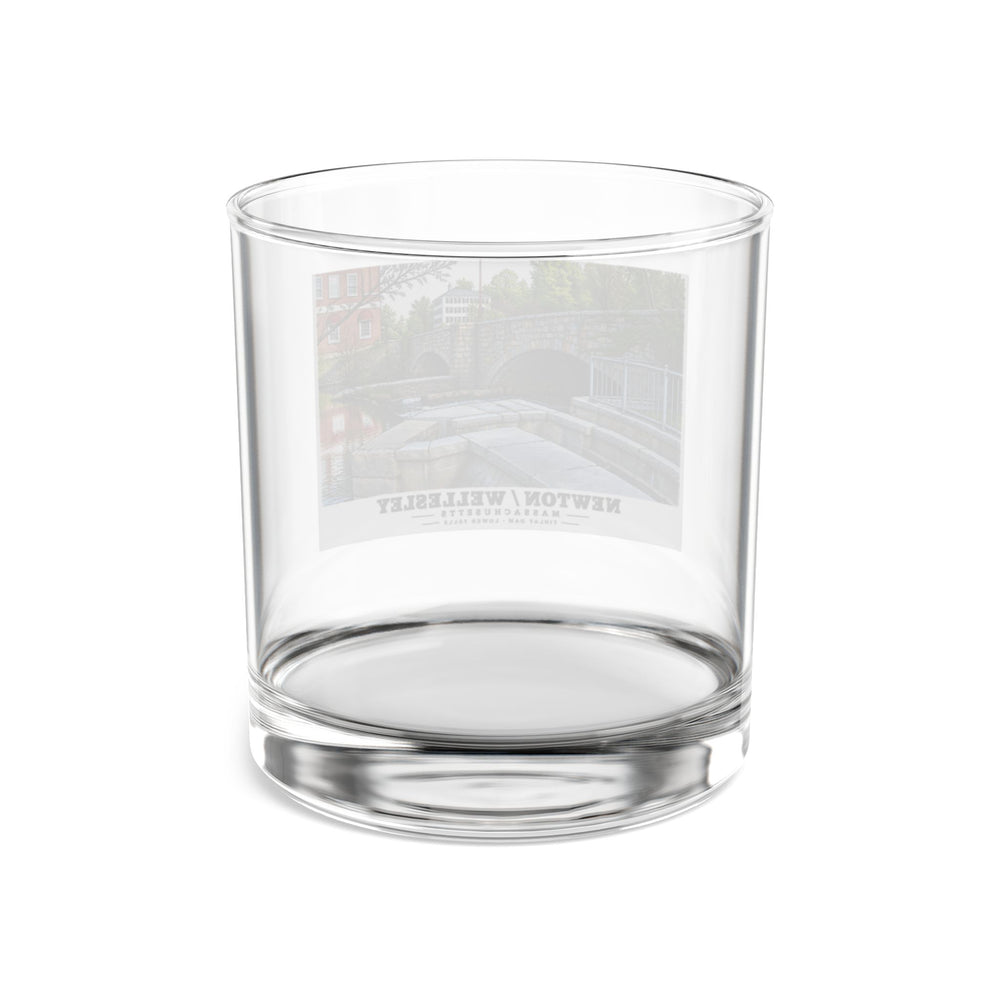 Rear view of clear rocks glass with Finlay Dam stone arches and water print and reversed lettering visible through the glass