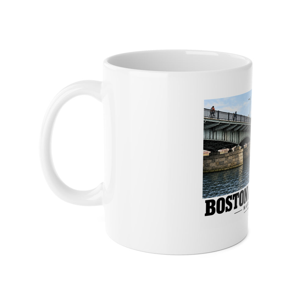 White mug with handle on the left and part of the Harvard Bridge print visible on the right