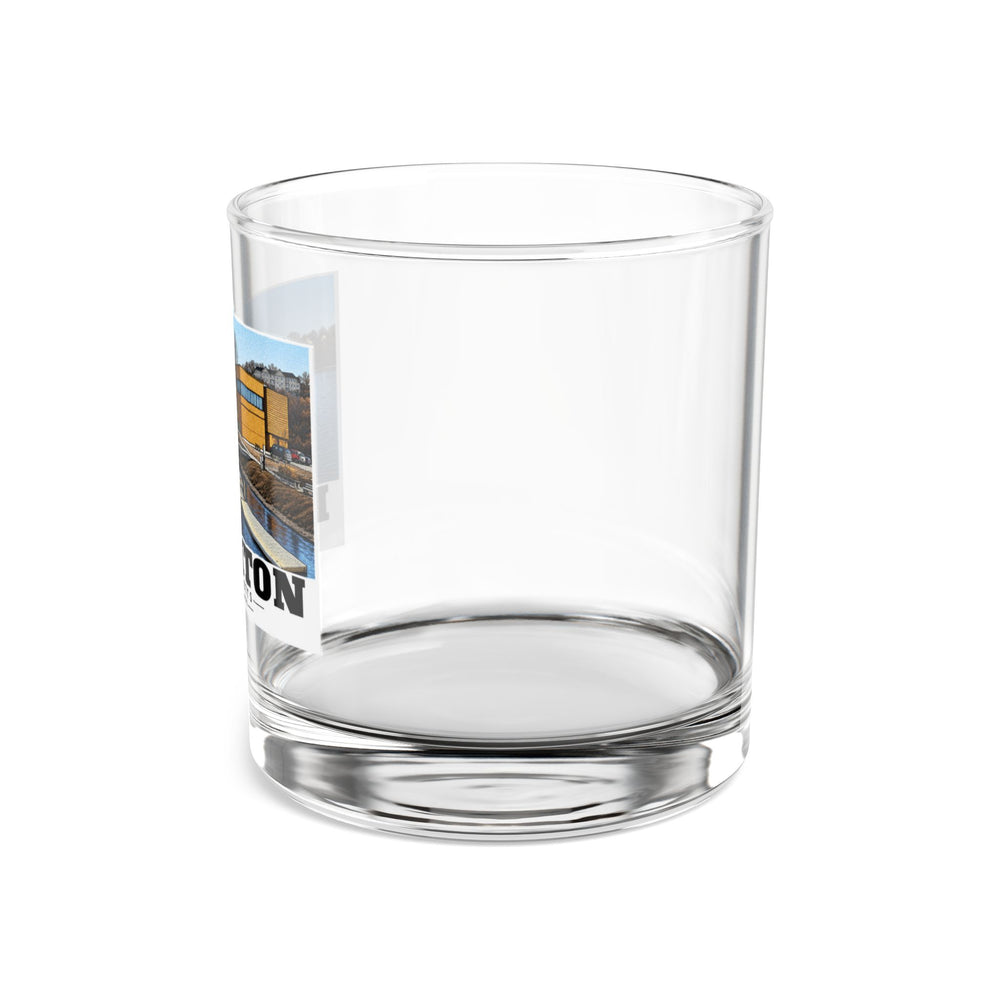 Side view of clear rocks glass with mostly unprinted surface and part of Community Rowing building, dock and boats print at left