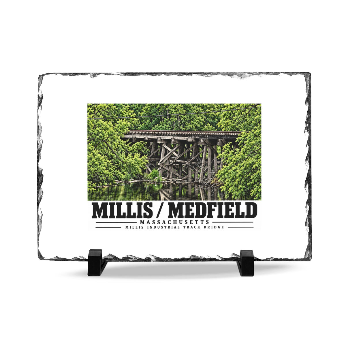 Rough-edged slate display on two black stands with Millis Industrial Track wooden railway trestle and green foliage artwork and Millis/Medfield lettering