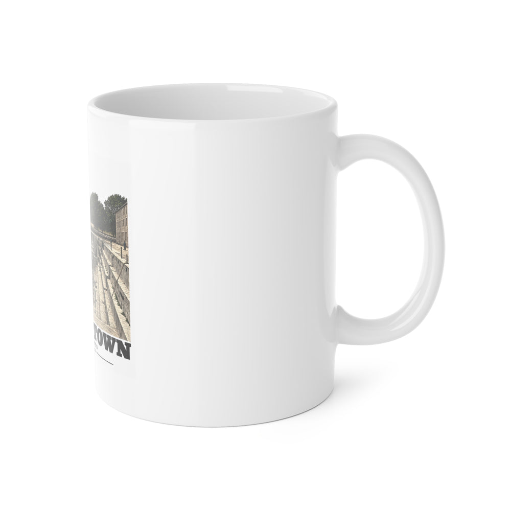 Right side of ceramic mug showing handle and edge of dry-dock artwork