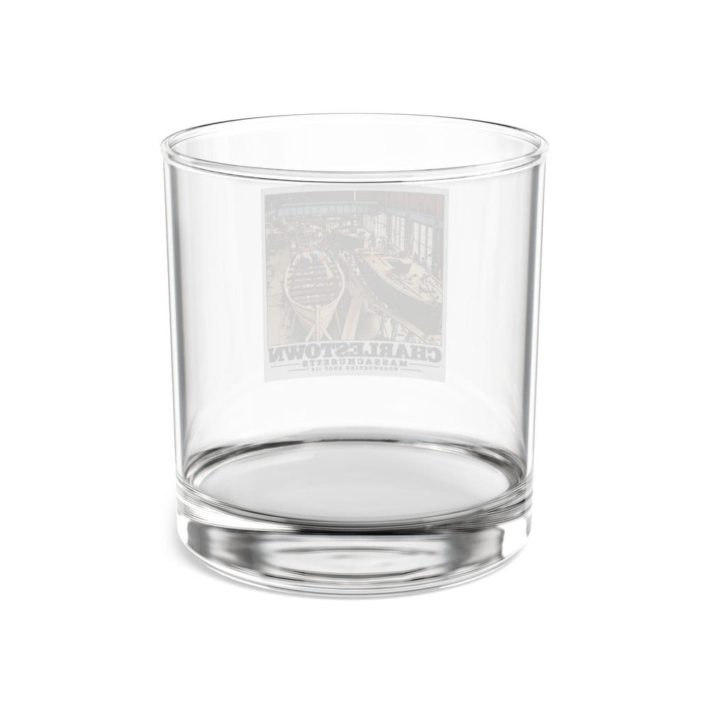 Rear of clear rocks glass showing reversed small-boat building artwork through glass