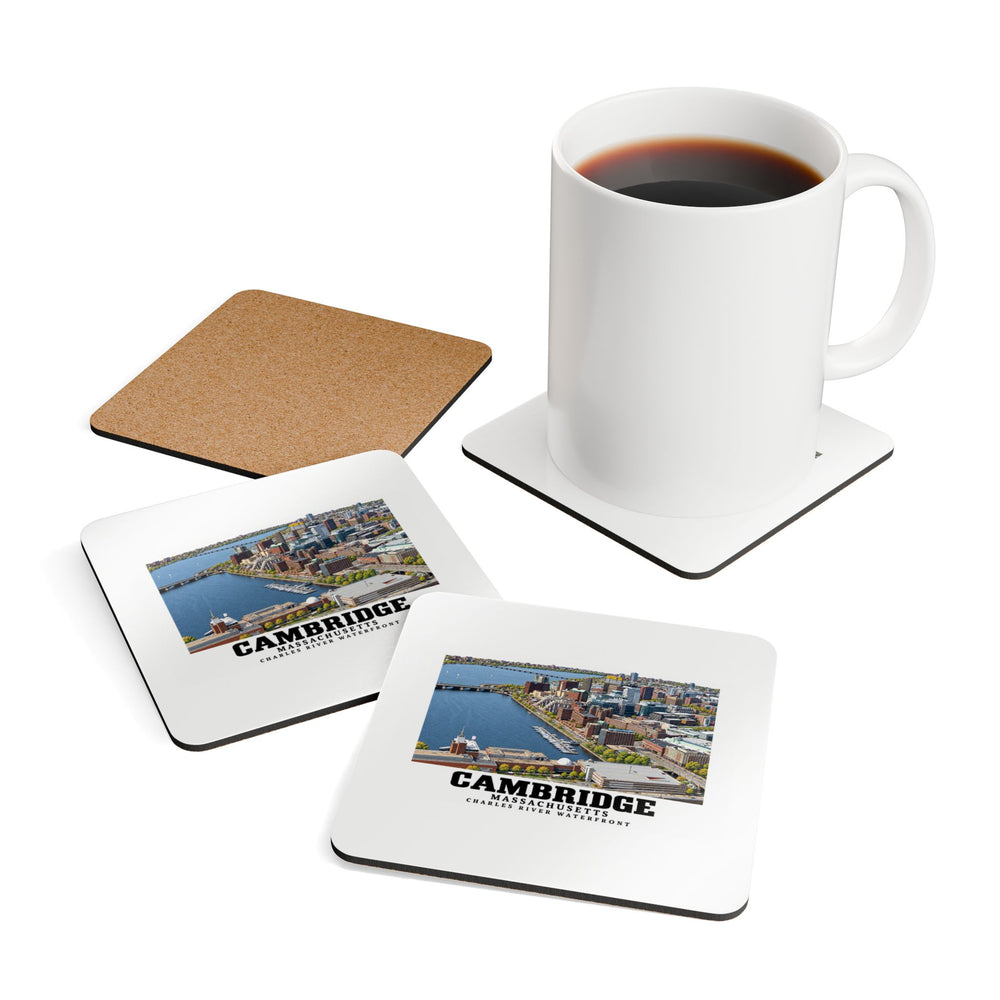 Coasters showing Cambridge Charles River waterfront aerial city view artwork beside a plain white mug of coffee and a coaster's cork reverse