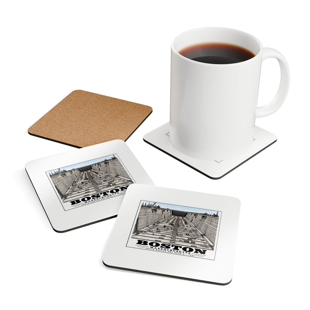 Coasters showing naval dry dock with concrete walls and rows of floor blocks artwork beside a plain white mug of coffee and a coaster's cork reverse