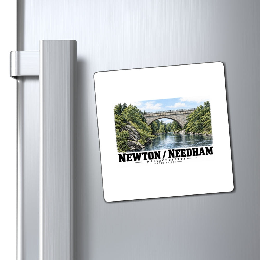 Square magnet with Echo Bridge artwork showing a stone arch over a river and trees, with Newton/Needham lettering displayed on a refrigerator door beside its handle.