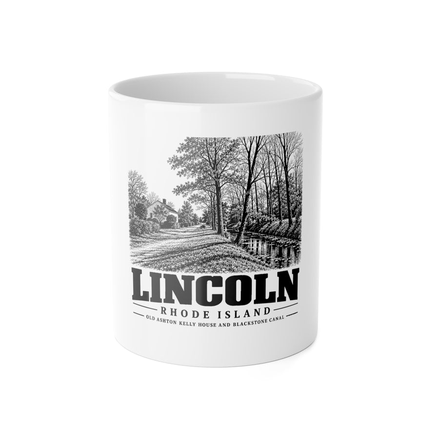 Front view of a white ceramic mug with black-and-white Lincoln, Rhode Island artwork of Old Ashton Kelly house and Blackstone Canal