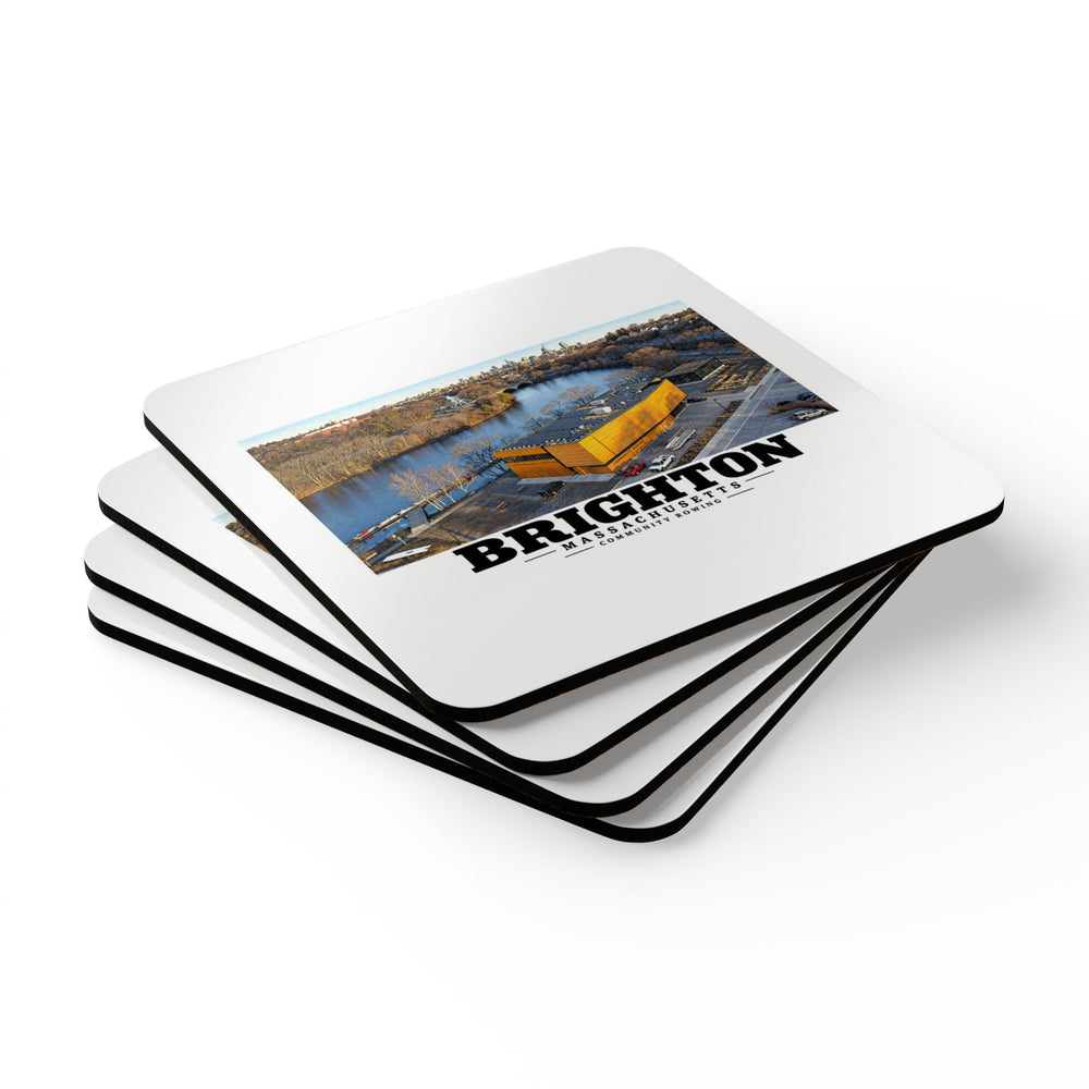 Stack of square coasters with Community Rowing aerial building and river artwork visible on the top coaster