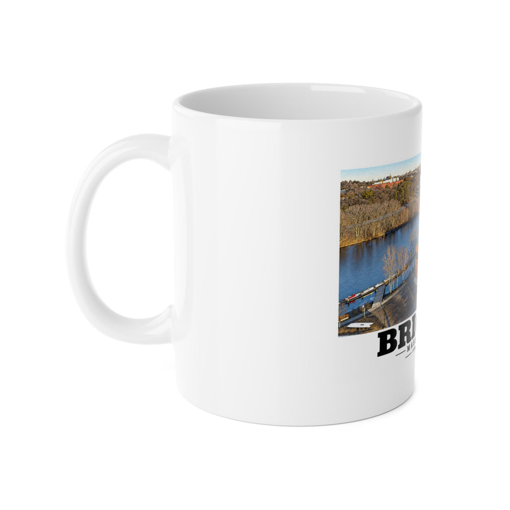 White mug with handle at left and part of the Community Rowing aerial building and river print at right