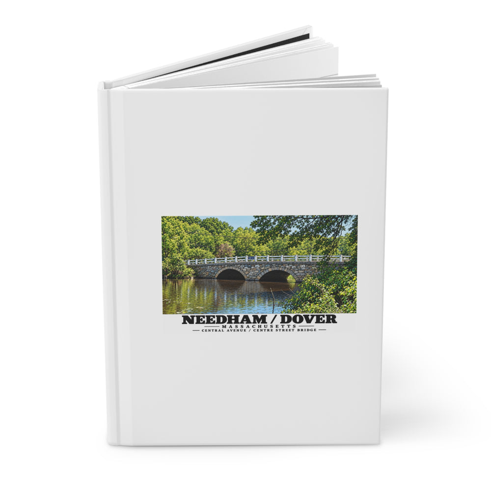 Partly opened white hardcover journal showing Central Avenue / Centre Street Bridge stone arches and river artwork on the front
