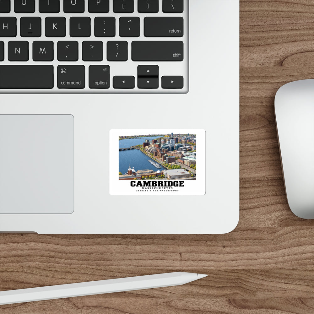 Sticker showing Cambridge Charles River waterfront aerial city view artwork on a laptop beside its keyboard