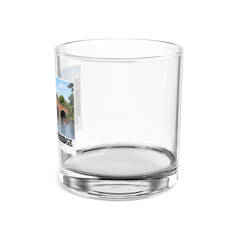 Side view of clear rocks glass with mostly unprinted surface and part of Eliot Bridge red brick arches and boats print at left