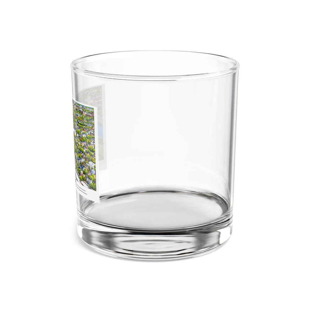 Side view of clear rocks glass with mostly unprinted surface and part of Charles River aerial city view with bridges, buildings and green trees print at left